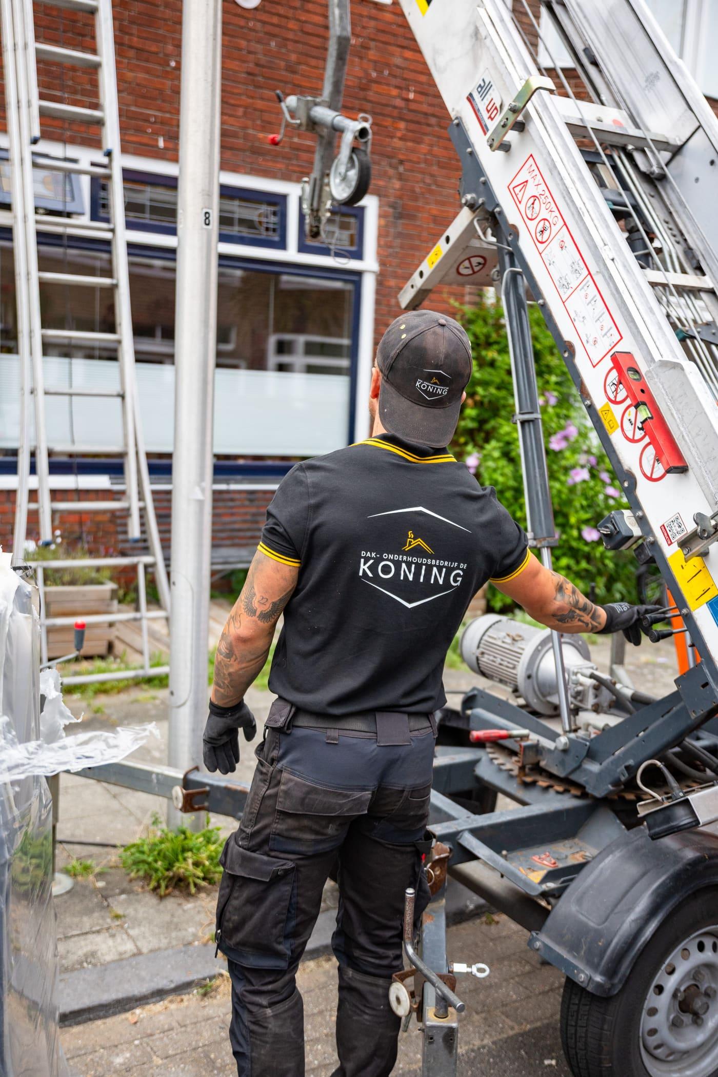 Vakman van De Koning bedient de pannenlift tijdens een dakrenovatie in Utrecht