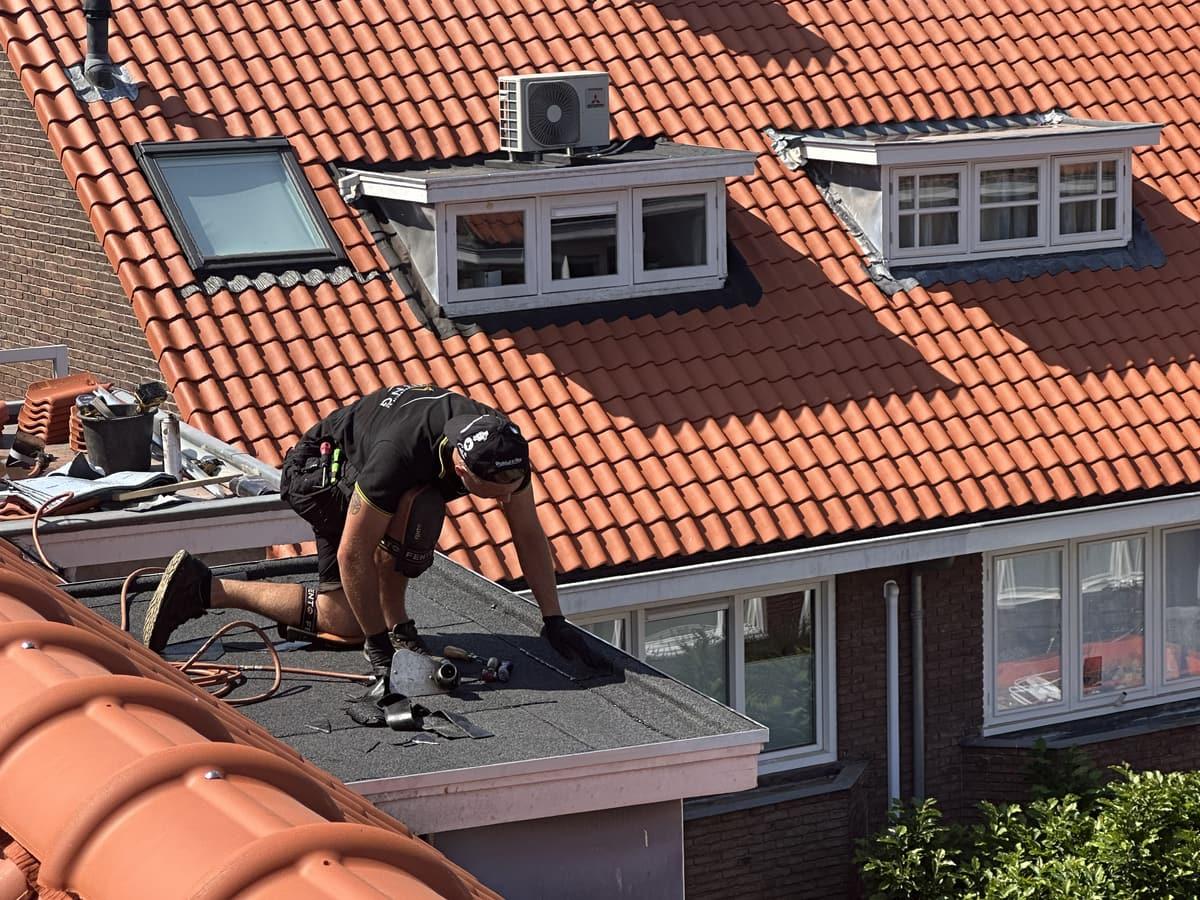 Dakdekker aan het werk op een hellend pannendak